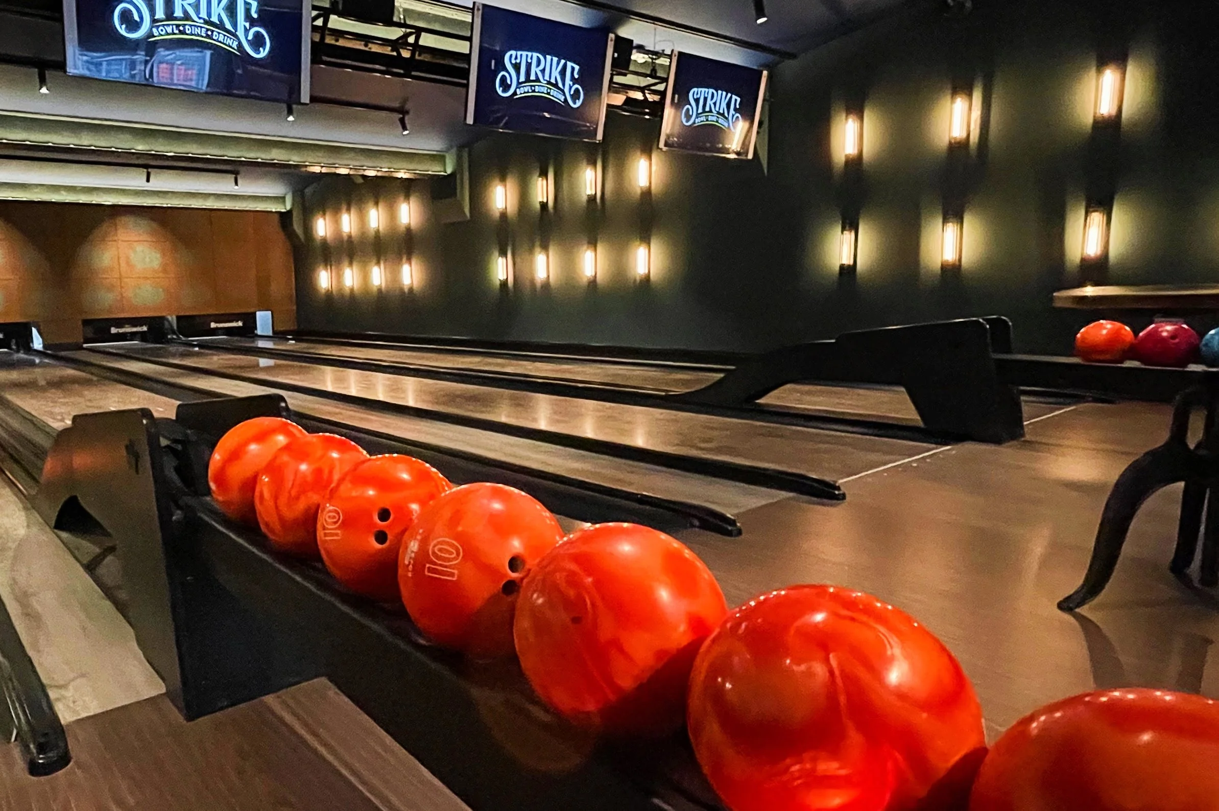 Table tennis player strikes bowling pins with ping-pong balls